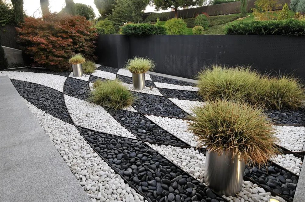 Geometric black and white pebble design with ornamental grasses